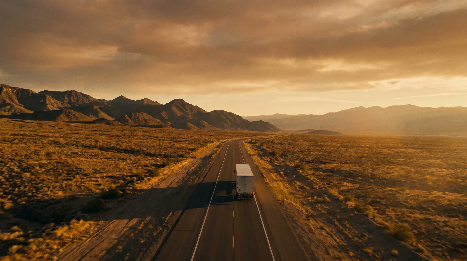 Aerial view of a highway stretching through open land at dusk