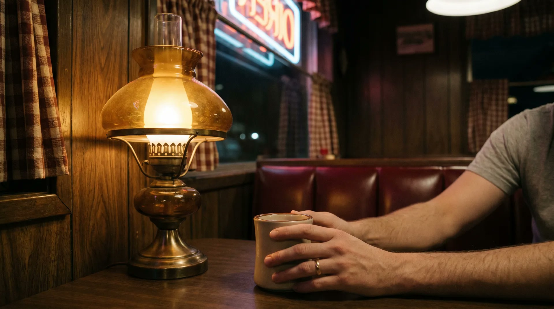 Silhouette of a figure inside the diner backlit by warm interior light